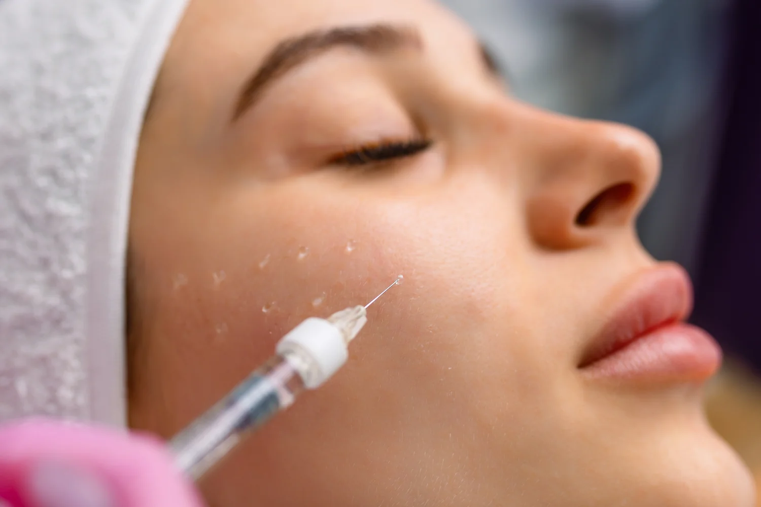 Woman receives cosmetic injection in clinical setting, enhancing beauty using modern techniques.